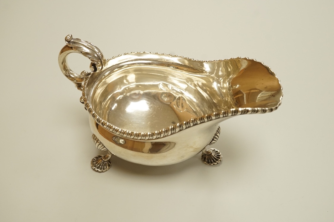 An Edwardian silver sauceboat, by The Goldsmiths & Silversmiths Co Ltd, London, 1903, with flying scroll handle and gadrooned border, length 16.3cm, 9.5oz.